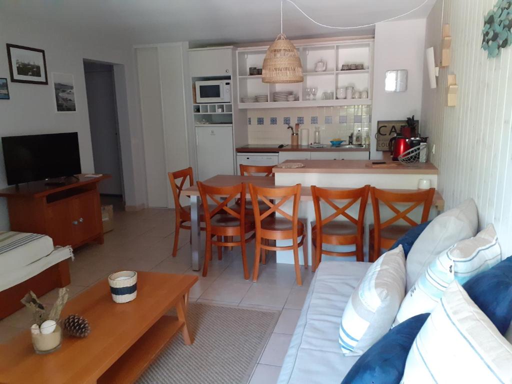 uma cozinha e sala de estar com um sofá e uma mesa em Appartement cosy em Moliets-et-Maa