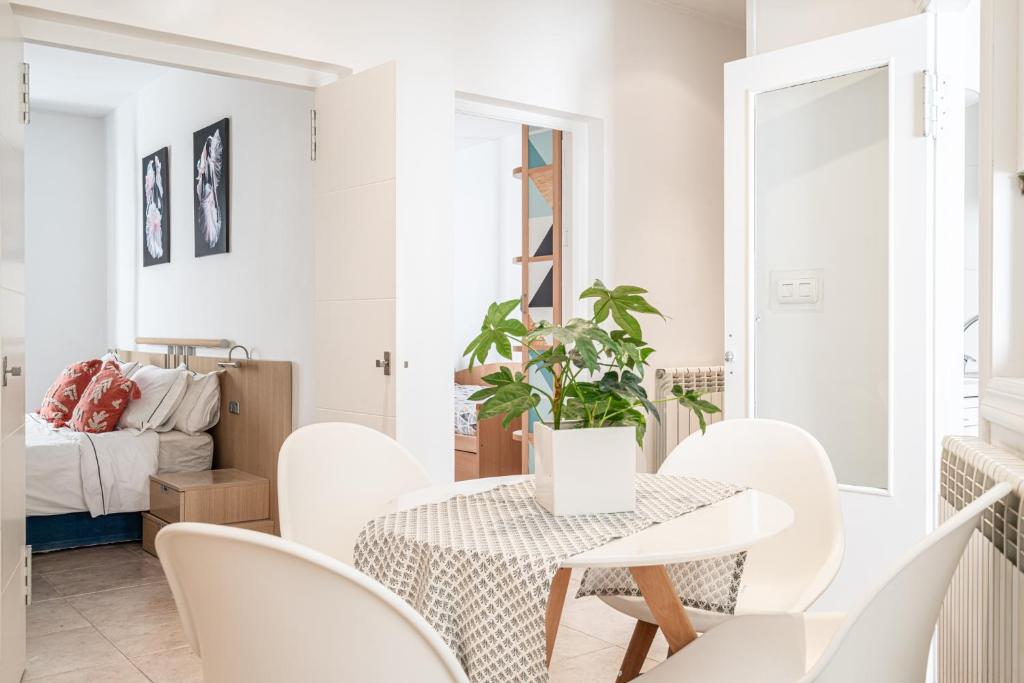 uma sala de jantar branca com uma mesa e cadeiras em Amandere em Pamplona