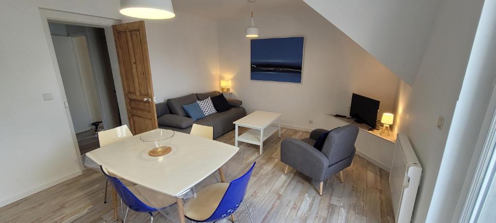 een kleine woonkamer met een witte tafel en stoelen bij Appartement 4 personnes à 100 m de la plage in Berck-sur-Mer