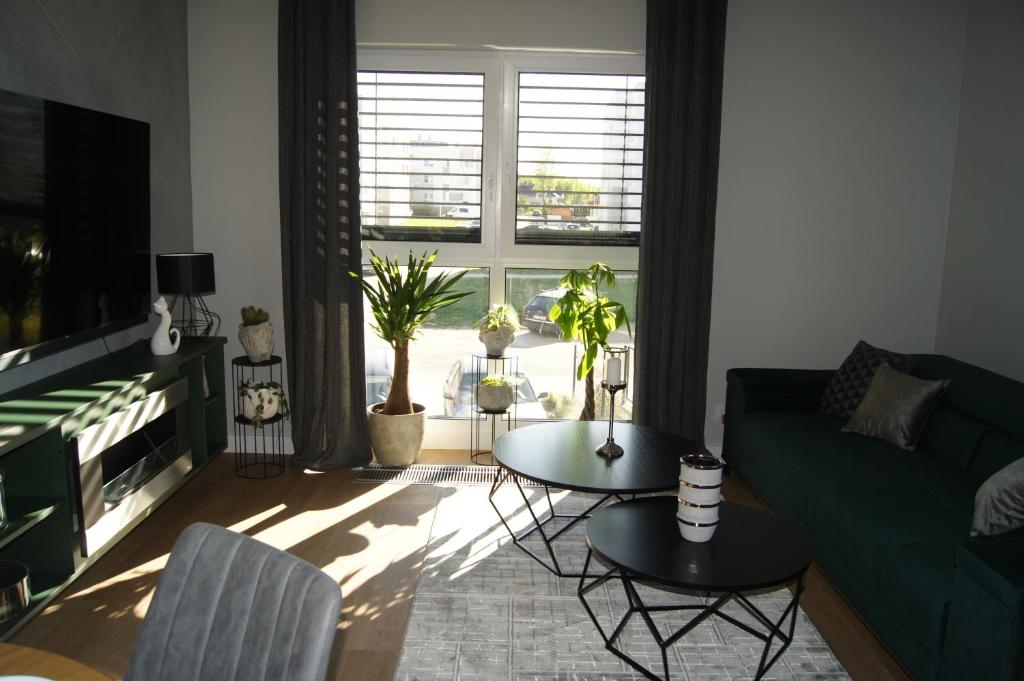 sala de estar con sofá verde y mesa en Apartament en Ostróda