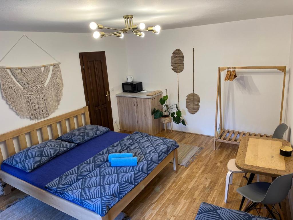 Schlafzimmer mit einem blauen Bett und einem Tisch in der Unterkunft New Fajka in Mikulov