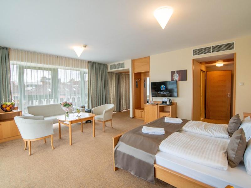 pokój hotelowy z łóżkiem i salonem w obiekcie Szent János Hotel w mieście Mohacz