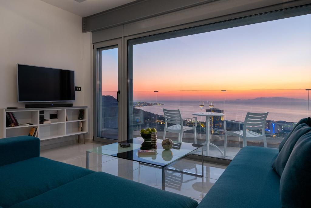 een woonkamer met een blauwe bank en een glazen tafel bij Rhodes SkyLine Suites in Ixia