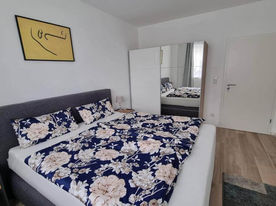 a bedroom with a bed with a blue and white comforter at New & Modern Apartment near Düsseldorf in Willich