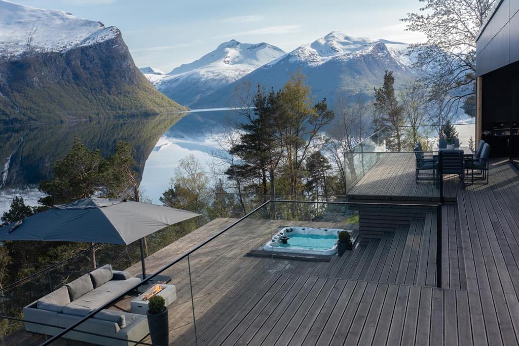 une maison avec une terrasse, une piscine et une montagne dans l'établissement VILLA KRISTINA / ÅNDALSNES, à Torvik