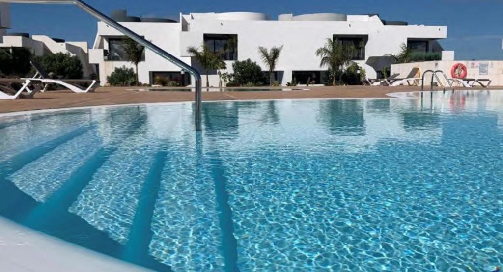 ein großes Schwimmbad vor einem Gebäude in der Unterkunft Suite Dreams Fuerteventura in Villaverde