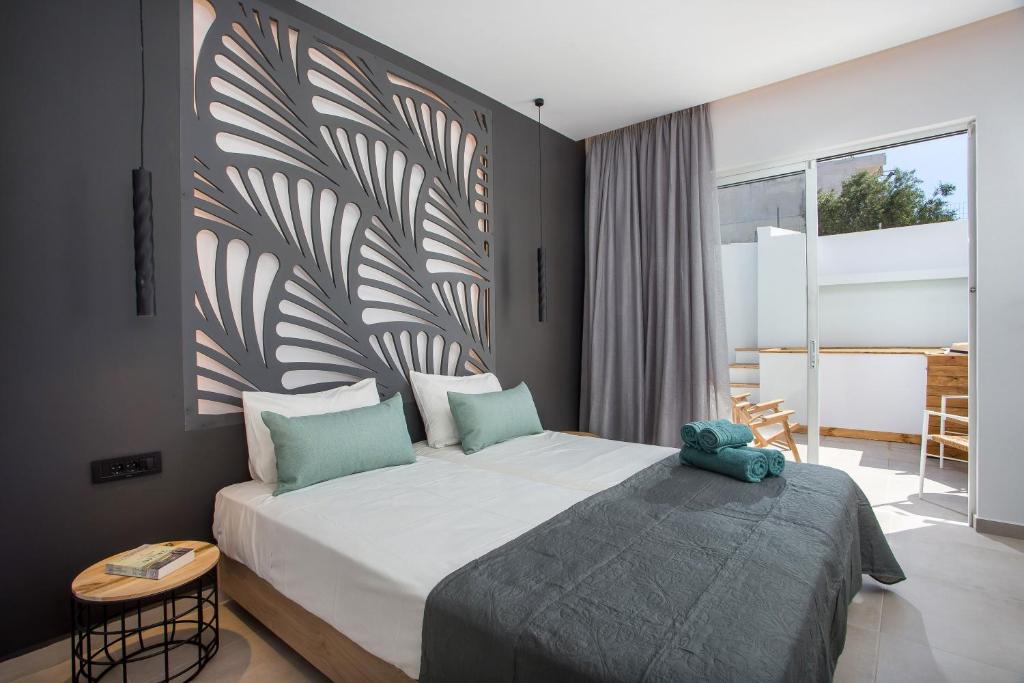 CasaStavris - Aparts & Pool Suites في فاليراكي: غرفة نوم بسرير كبير عليها دبدوب