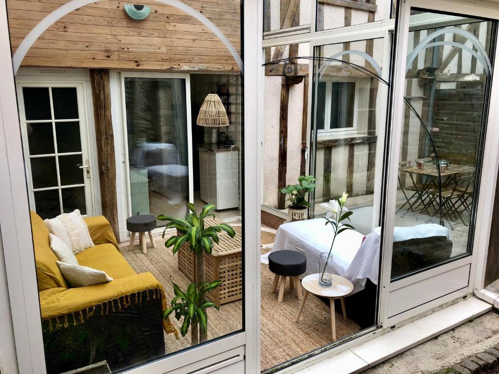 a screened in porch with a couch and a table at T2 style cottage - Véranda & Terrasse extérieure in Tours