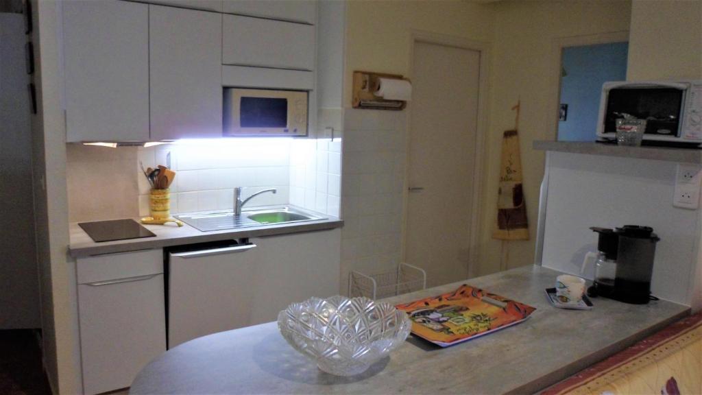 a kitchen with white cabinets and a counter top at valras appartement T2 proche mer et port in Valras-Plage