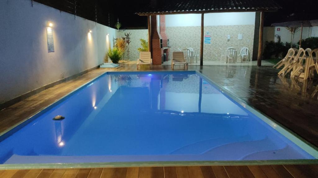 a large blue swimming pool in a building at Confortável Duplex a 100 Metros da Praia in Porto Seguro
