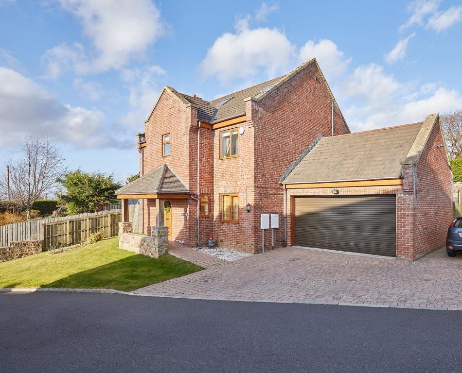 a brick house with a garage on a driveway at The Chase, Luxury Hot Tub Retreat, Pets Welcomed in Dipton