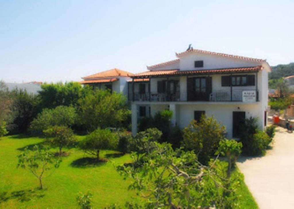 a house with a green yard in front of it at Skiathos Maria Apartments in Skiathos