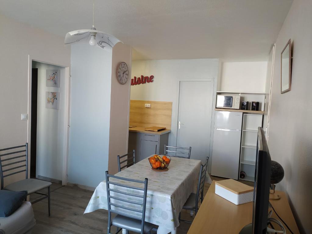 eine Küche mit einem Tisch und einer Obstschale darauf in der Unterkunft Appartement restauré à 50 m de la plage in Saint-Hilaire-de-Riez