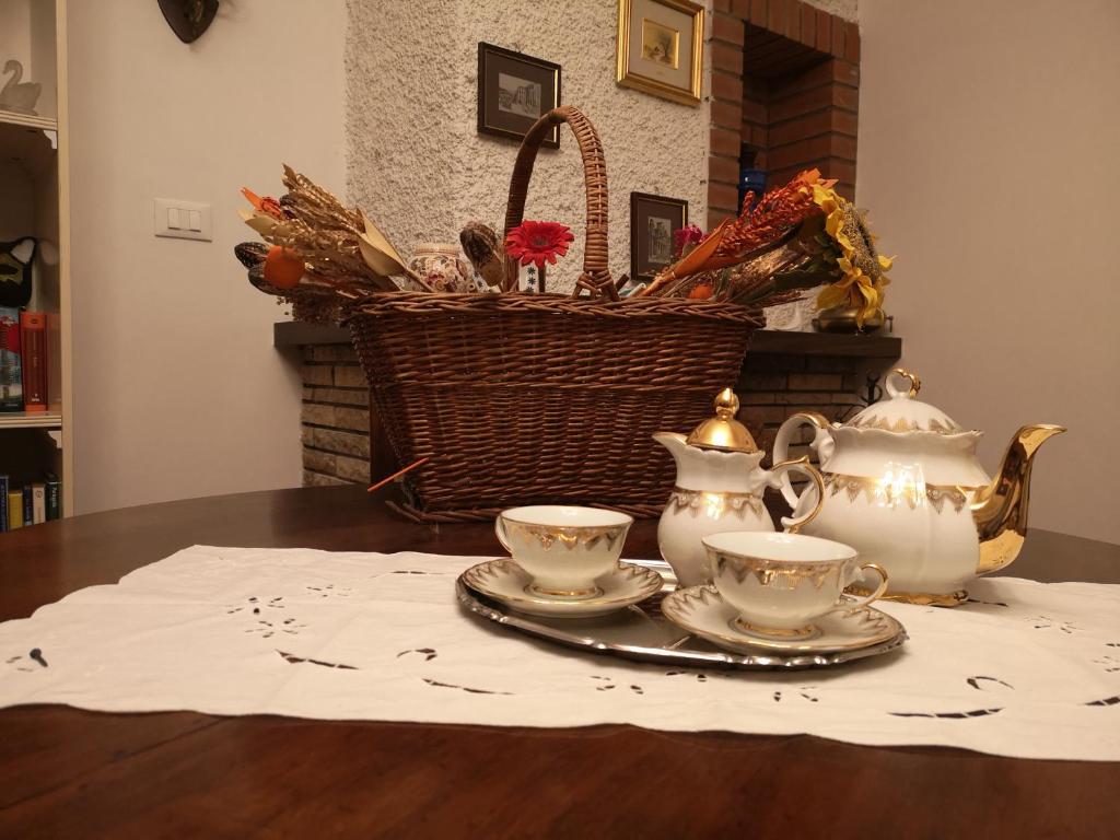 a table with two tea cups and a basket on it at B&B GENOVA COUNTRY in Fegino