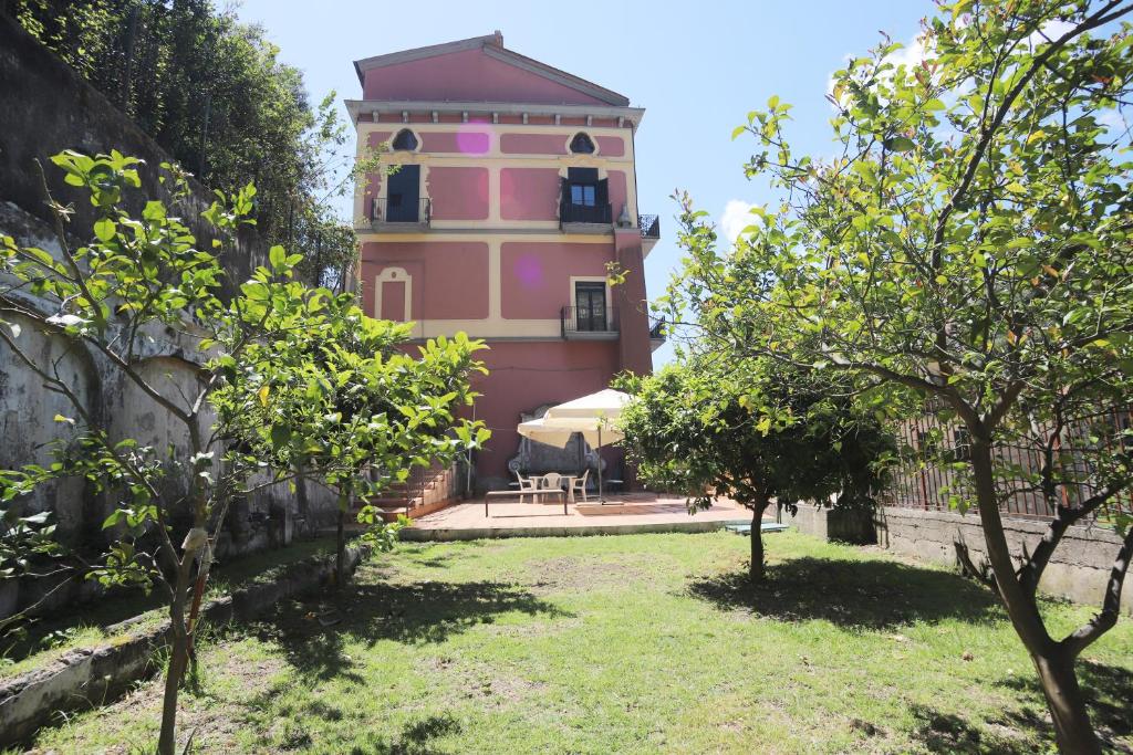 una casa rosa con una mesa y sillas en un patio en PALAZZO PELLEGRINO vietri, en Vietri