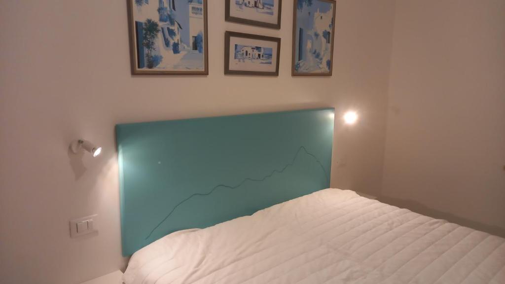 uma cama com uma cabeceira azul num quarto em Struttura con accesso diretto in spiaggia em San Felice Circeo
