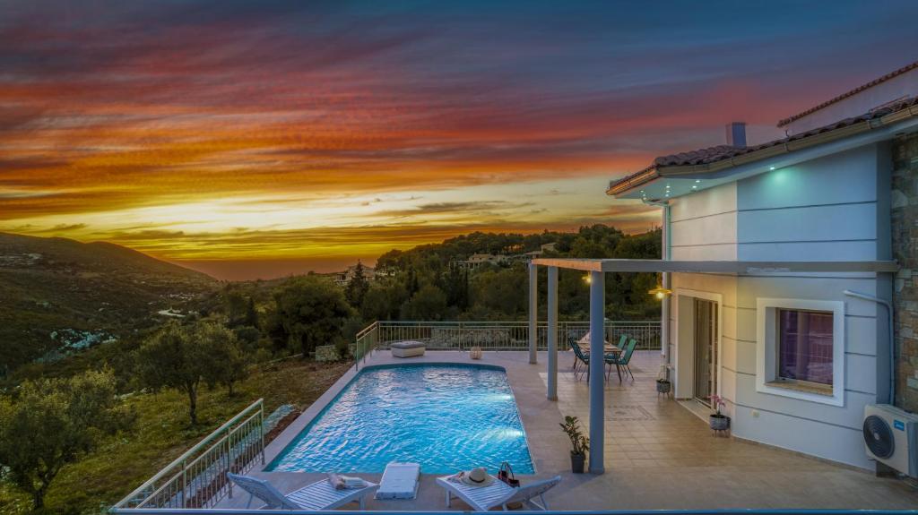 a villa with a swimming pool and a sunset at Villa Guesto in Anafonítria