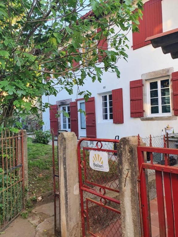 un portail rouge devant une maison avec volets rouges dans l'établissement Maison au coeur de la rue pietonne, à Saint-Jean-Pied-de-Port