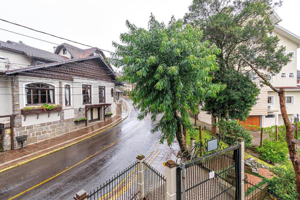 una calle lluviosa con una casa y una valla en Rosa Edifício Villa Rossa, en Gramado