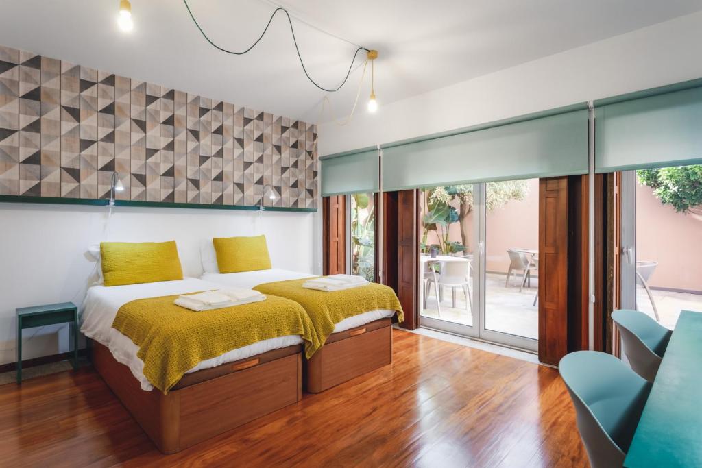 een slaapkamer met een bed met een gele sprei bij BeSmart Residence in Aveiro