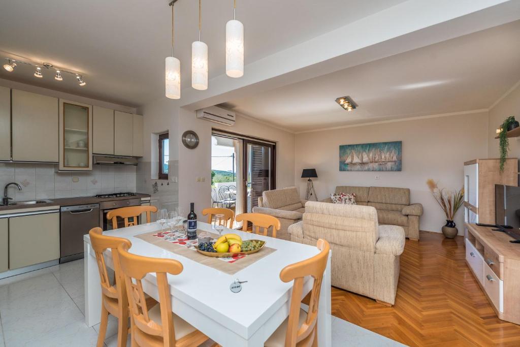 a kitchen and living room with a table and chairs at Stedi Apartment in Lukoran