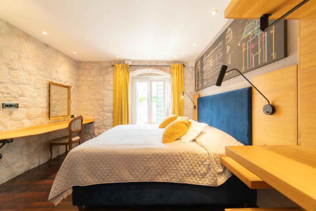 um quarto com uma cama, uma secretária e uma janela em Domus Maritima em Trogir