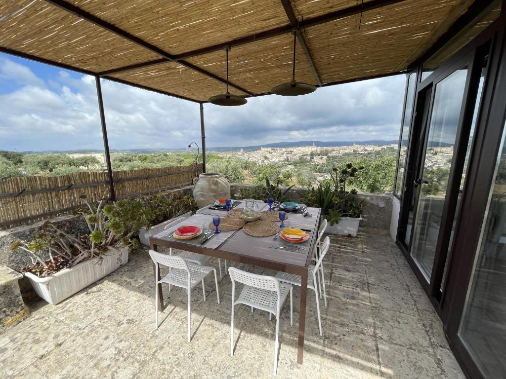 a table and chairs on a patio with a view at Il Dammuso di Noto - Villa con Piscina privata in Avola