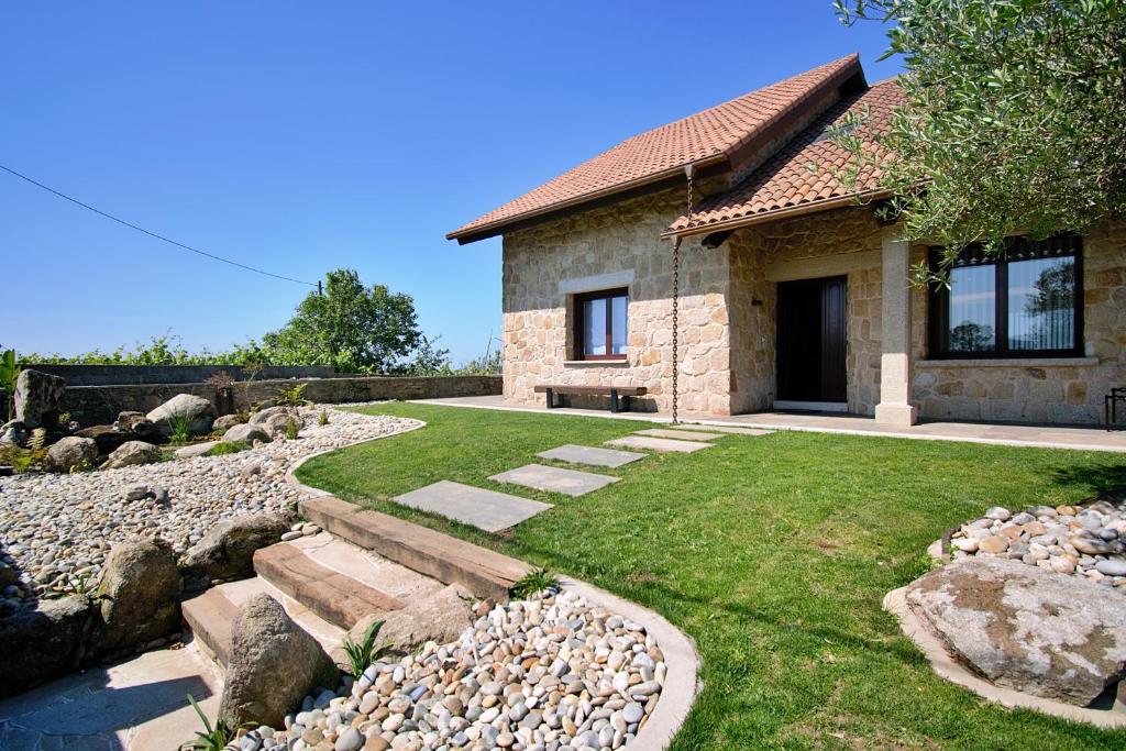 una casa de piedra con un patio con rocas en GALIHOST - Casa Esclavi, en Cambados