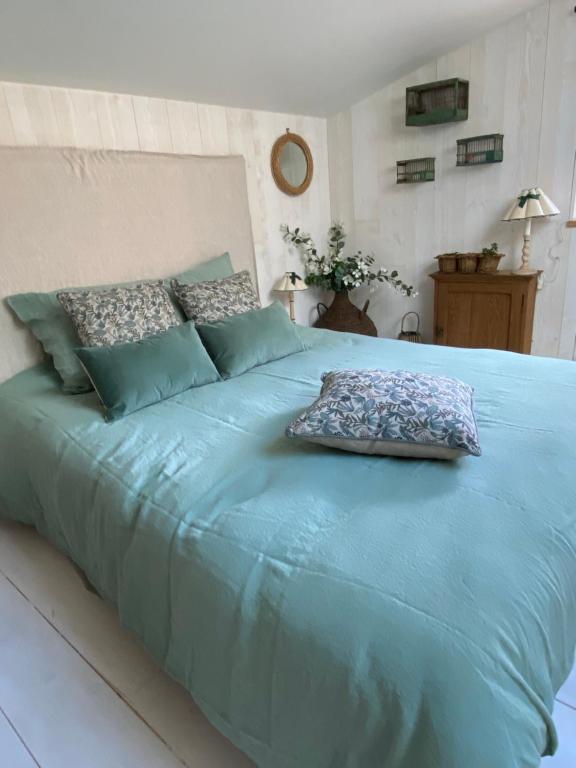 ein großes blaues Bett mit zwei Kissen darauf in der Unterkunft Le Celadon in Montaigu-Vendée