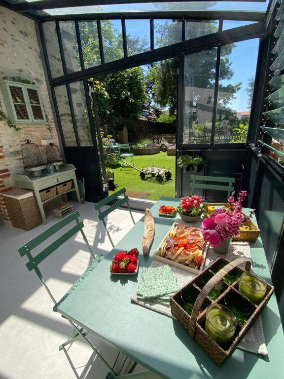 einen Picknicktisch mit Essen auf einer Terrasse in der Unterkunft Le Celadon in Montaigu-Vendée