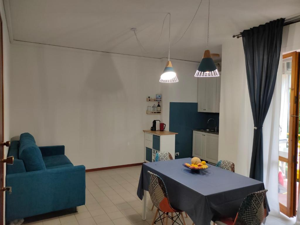 een woonkamer met een tafel en een blauwe bank bij Casa Polly in Follonica