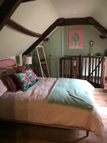 a bedroom with a bed in a room with a staircase at Dunster Luxe Nook in Dunster