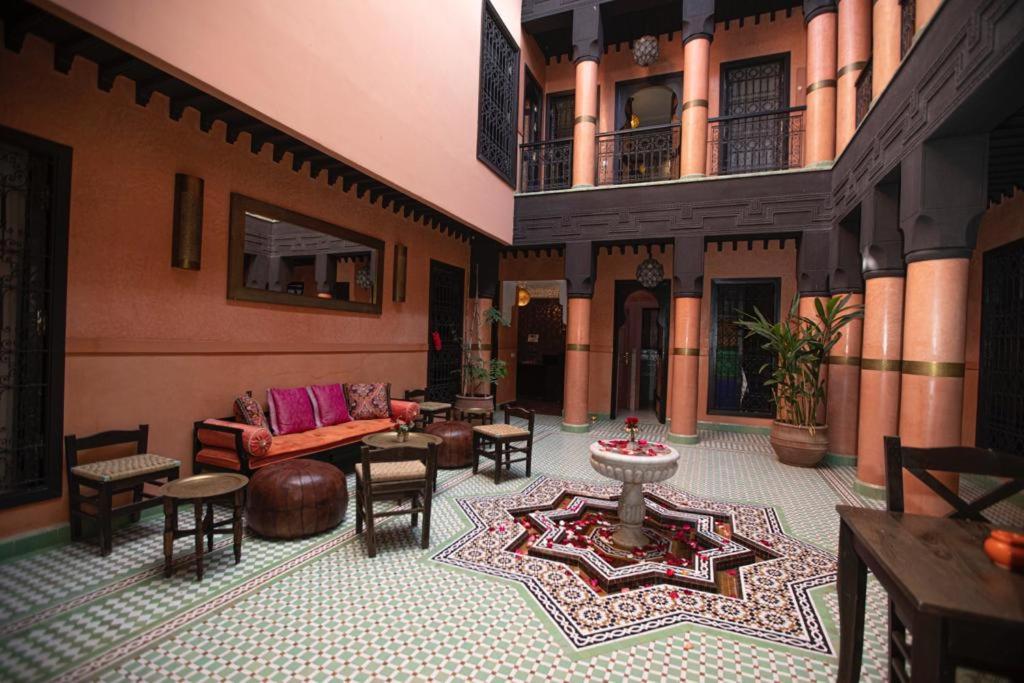 ein Wohnzimmer mit einem Sofa und Stühlen in einem Gebäude in der Unterkunft Riad Sultan Suleiman in Marrakesch