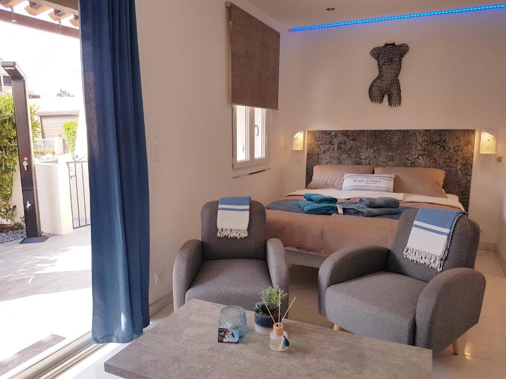 1 dormitorio con 1 cama, 2 sillas y mesa en Villa Calma Port Venus Village Naturiste Piscine & vélo en Cap d'Agde