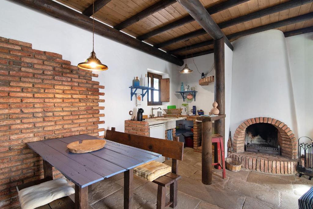 uma cozinha com uma mesa de madeira e um forno de tijolos em Algarve Charming 1b Mezzanine Villa em Santa Bárbara de Nexe