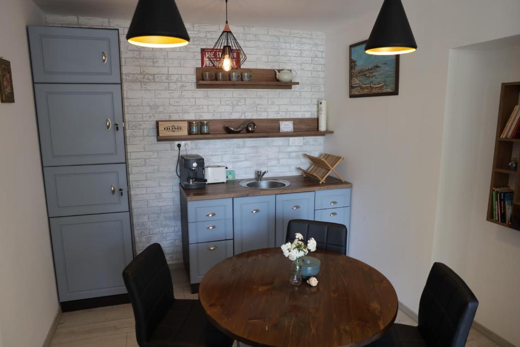 een keuken met een tafel met stoelen en een wastafel bij Guest house Dimant in Boergas