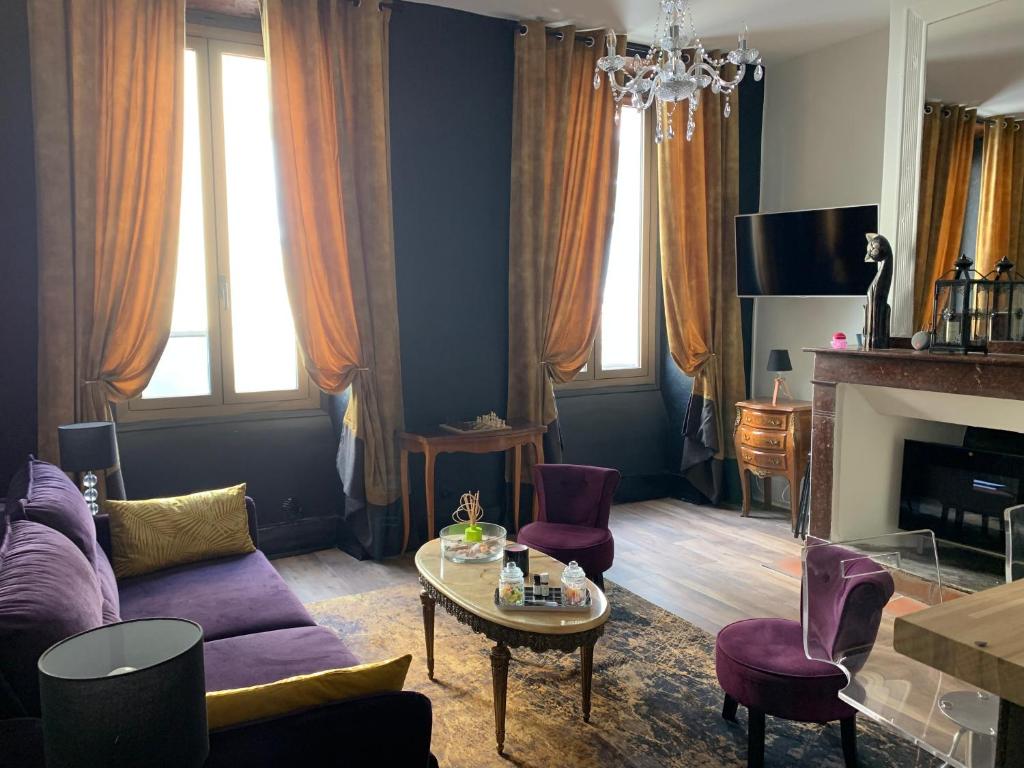 a living room with a couch and a table at Duo Romantic in Bagnères-de-Bigorre