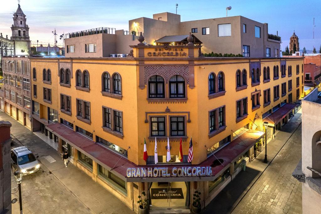 un gran edificio amarillo con un cartel. en Gran Hotel Concordia San Luis Potosi en San Luis Potosí