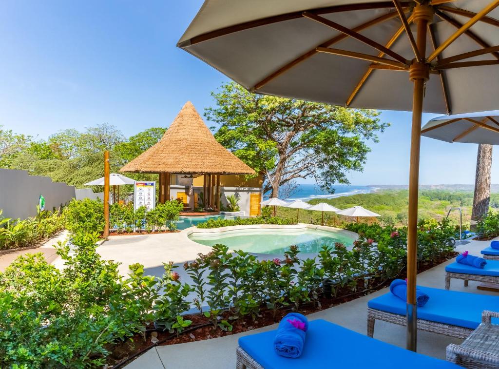 un complexe avec une piscine et un kiosque dans l'établissement Hotel Boutique Lagarta Lodge, à Nosara