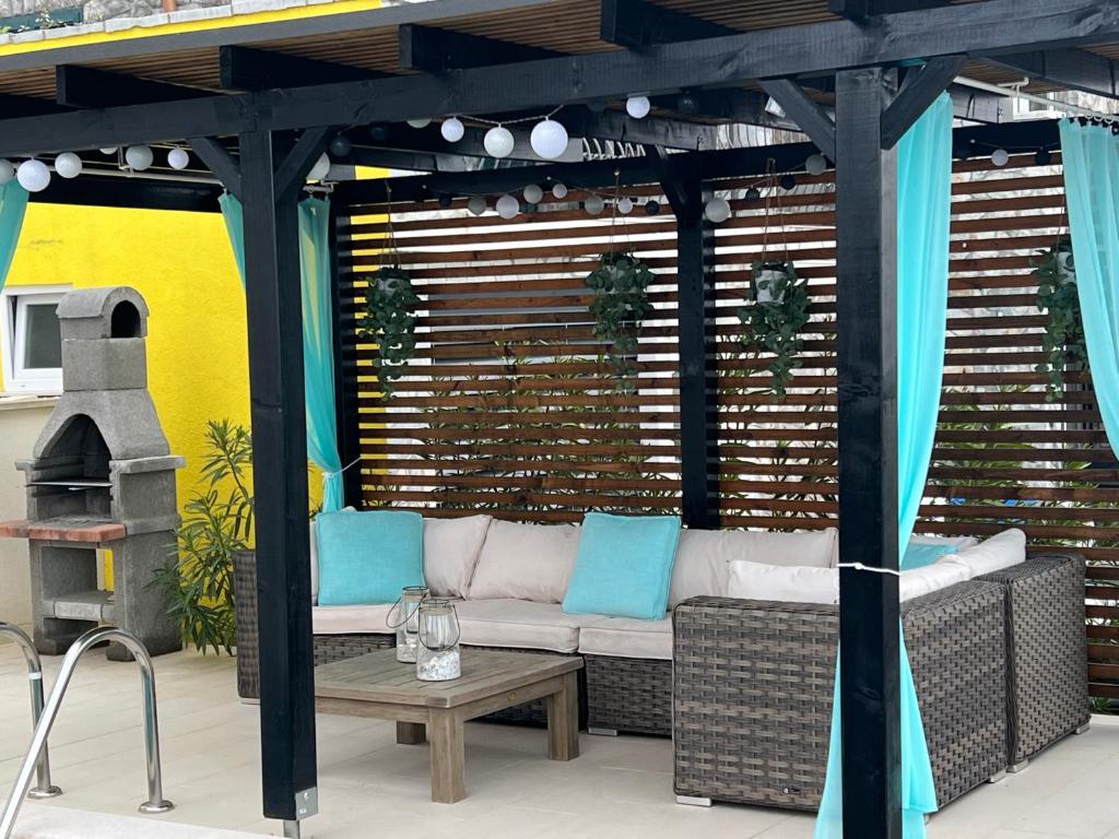 eine Pergola mit einem Sofa auf einer Terrasse in der Unterkunft Apartman Mateo in Njivice