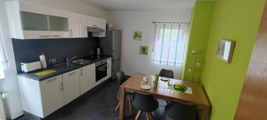 a small kitchen with a wooden table and a dining room at Ferienwohnung Maria Laach in Glees