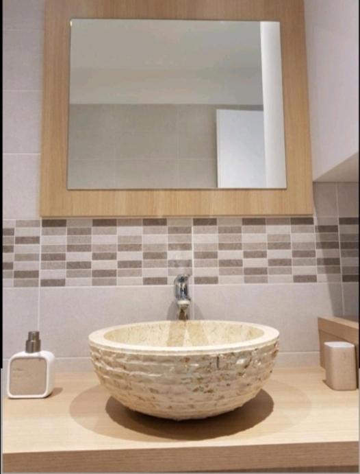 ein Badezimmer mit einem Steinwaschbecken und einem Spiegel in der Unterkunft Apartman Mateo in Njivice