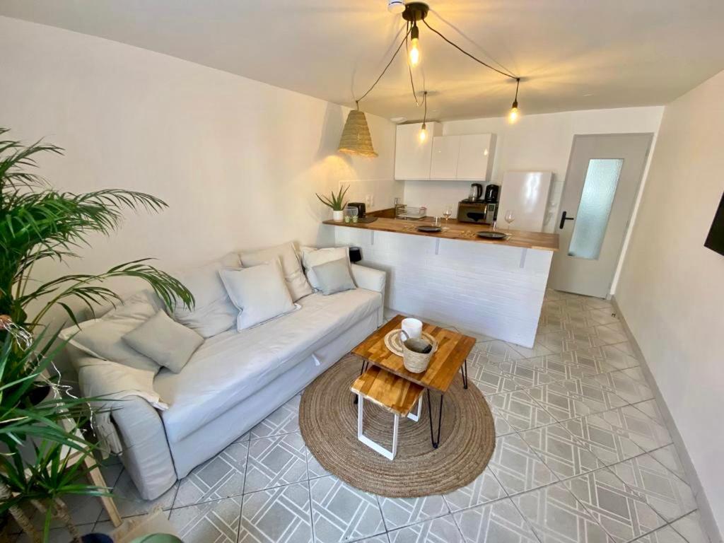 sala de estar con sofá blanco y mesa en La Cascade verte /Appartement /jardin /parking en Braux