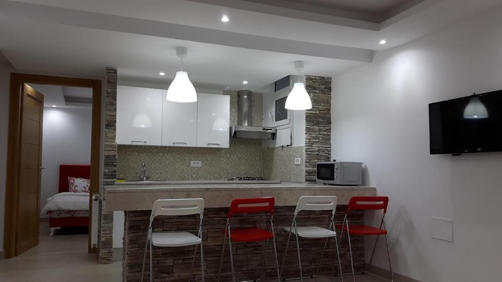 a kitchen with red chairs and a counter with a sink at Ain Zaghouan en face de Tunisia Mall Lac 2 in Tunis
