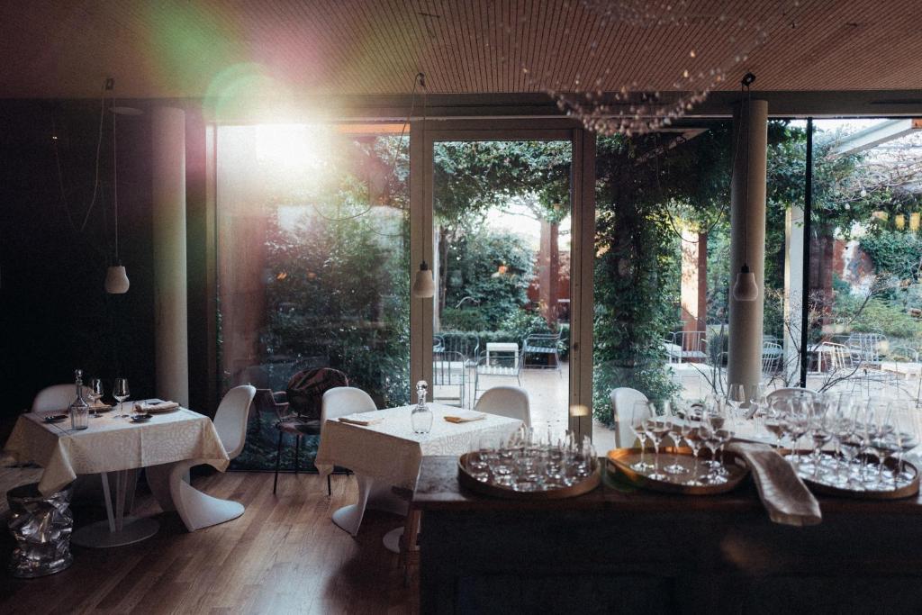 un restaurante con mesas y sillas y una gran ventana en Ristolocanda Grani Di Pepe, en Flaibano