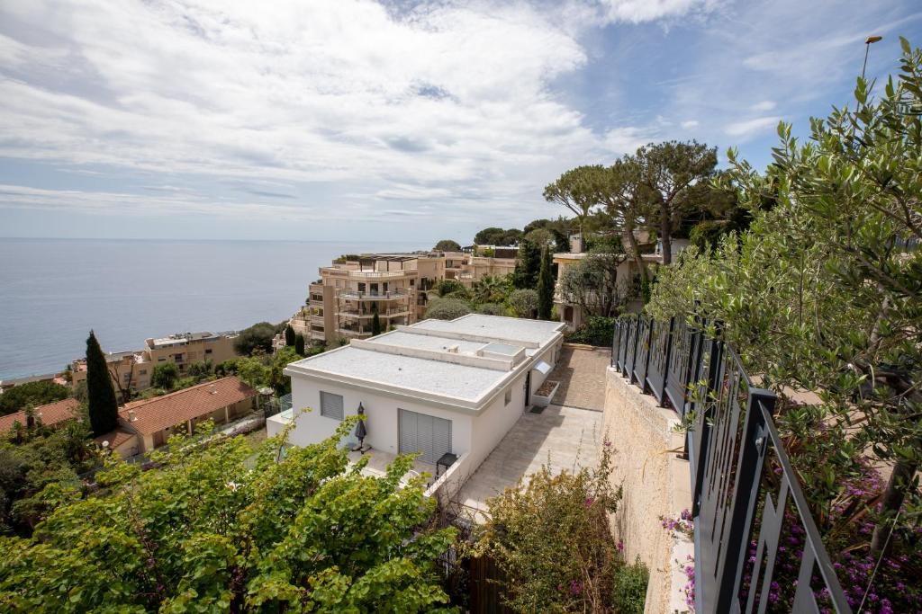 a white building on a hill next to the ocean at Mont des Olives - Cap D'ail- app4 in Saint-Antoine