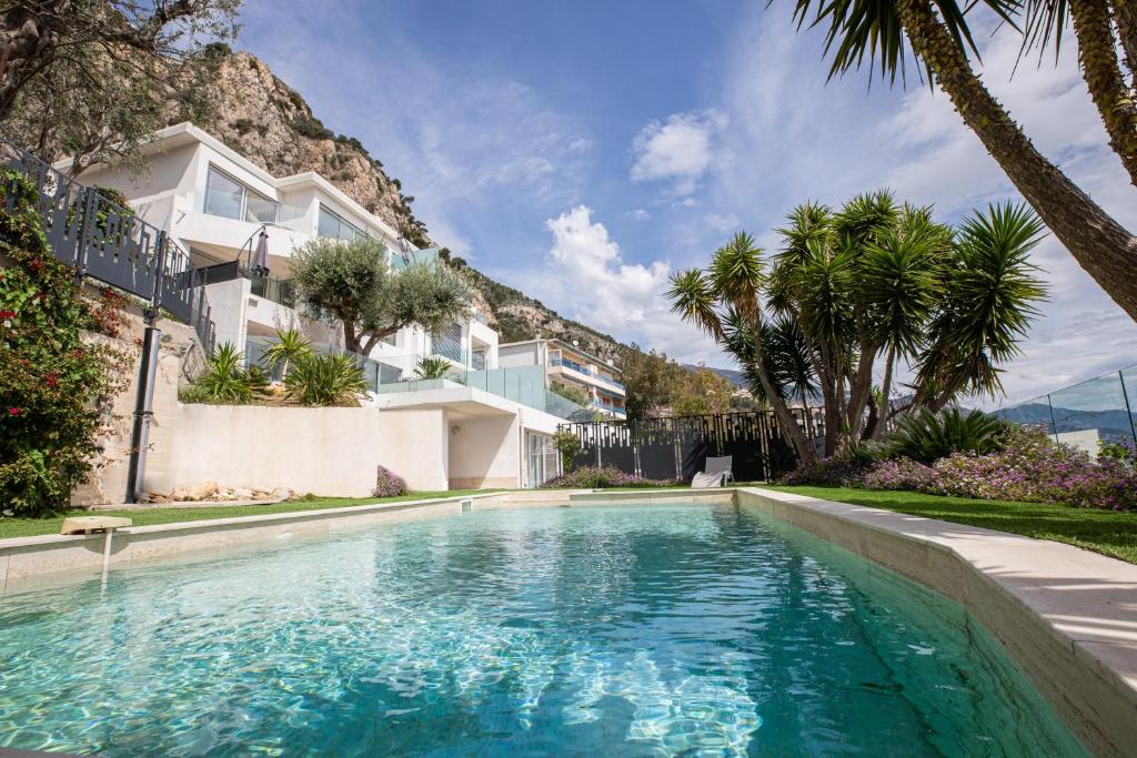 a swimming pool in front of a house at Mont des Olives - Cap D'ail- app4 in Saint-Antoine