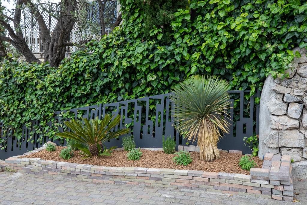 a garden with a fence and some plants at Mont des Olives - Cap D'ail- app4 in Saint-Antoine