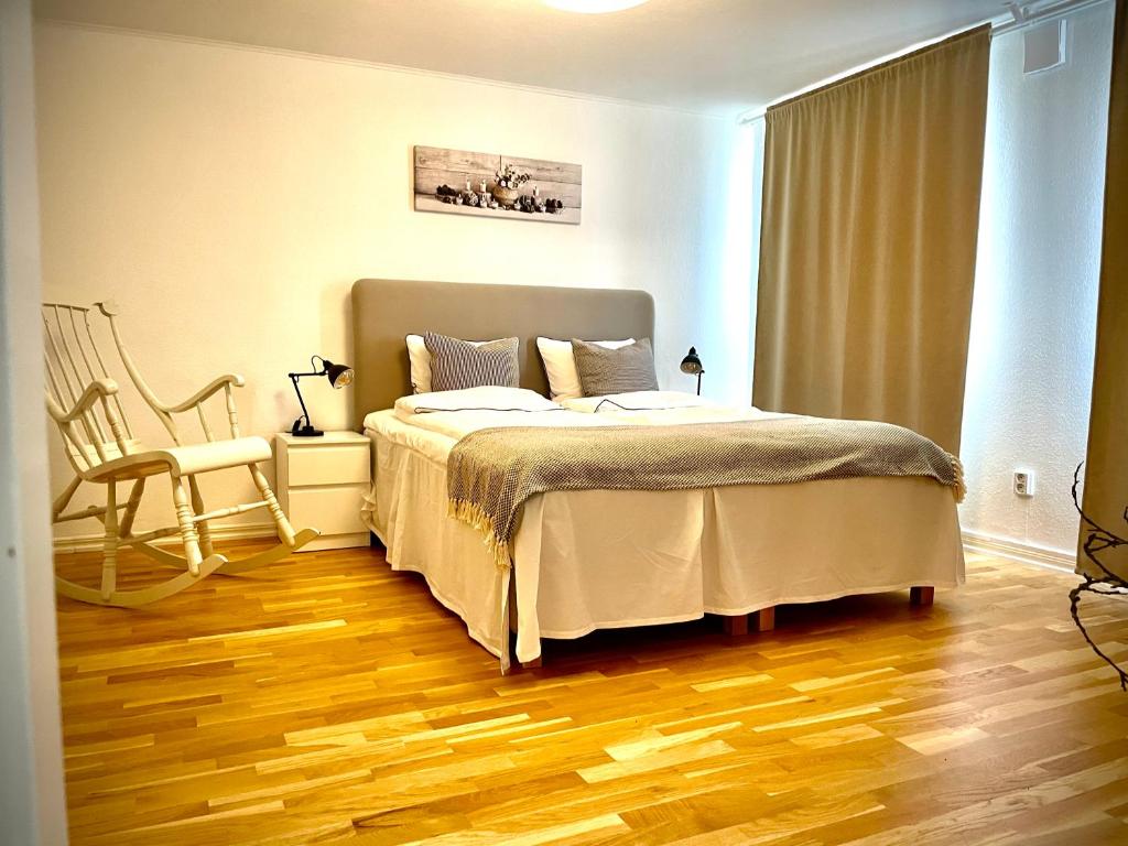 a bedroom with a bed and a wooden floor at Trelleborg Central Vila in Trelleborg