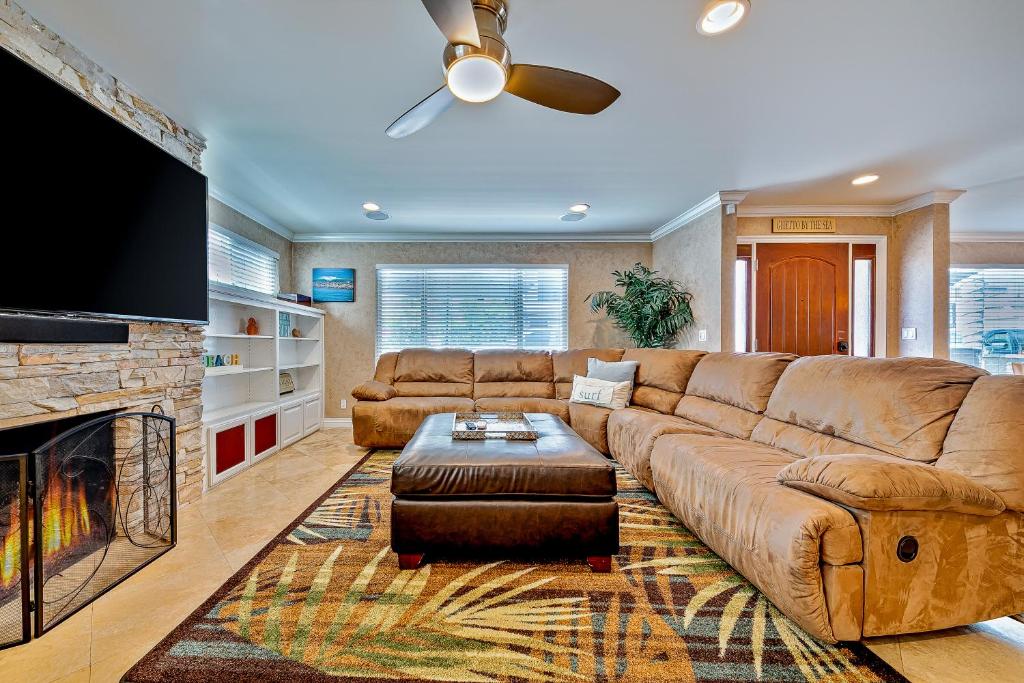 ein Wohnzimmer mit einem braunen Sofa und einem Kamin in der Unterkunft Palm Tree Getaway in Newport Beach